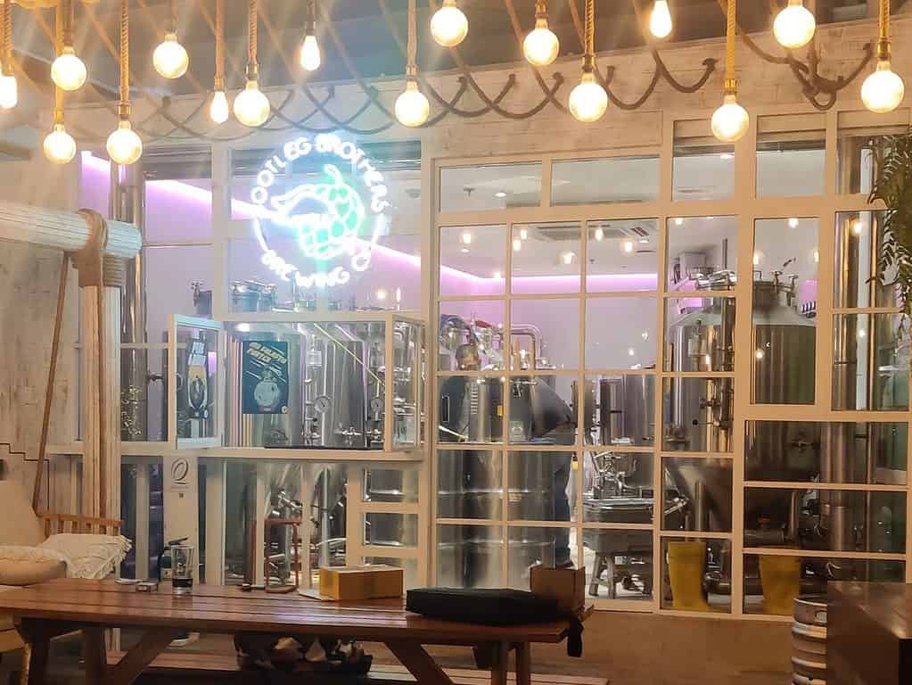 Front of Bootleg Brothers brewpub with all the lights. Through the glass, the brew equipment can be seen.