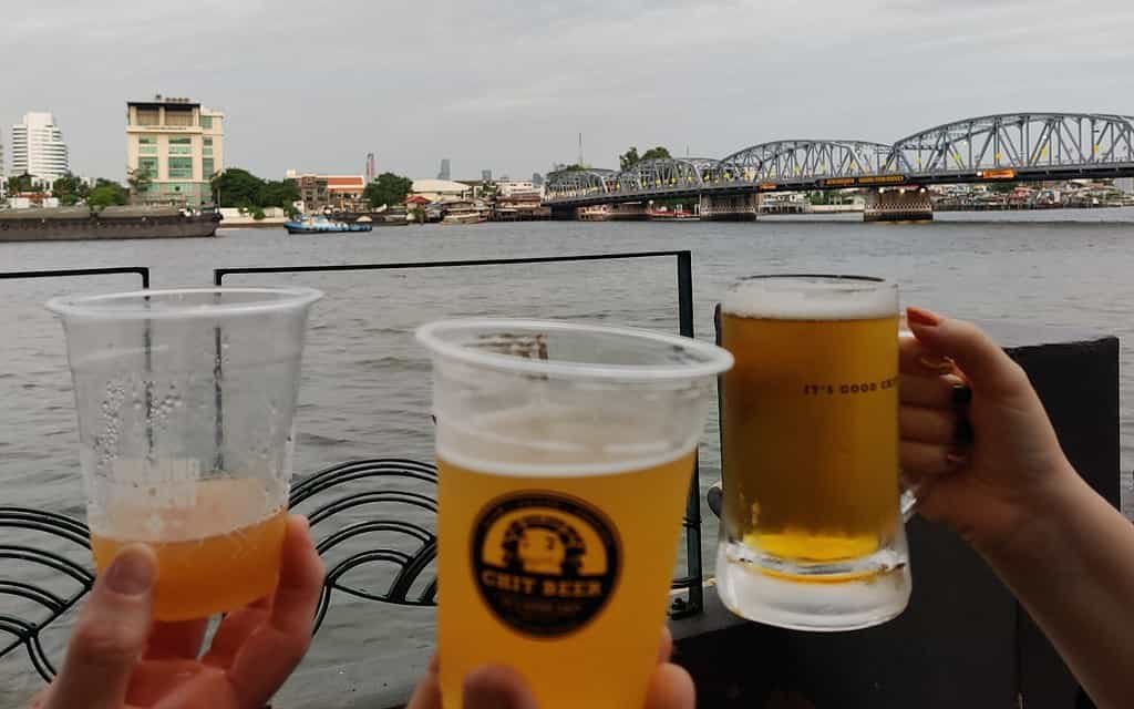 Chit craft beer branded beer mugs giving a cheers at Chit Hole, by Chit Brewery in Bangkok Thailand