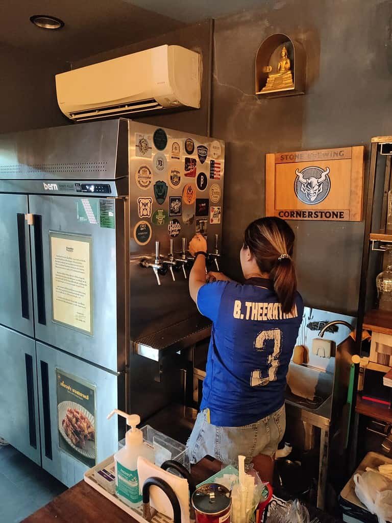 Craft Room Sathorn - craft beer bar in Bangkok Thailand. Waitresspouring a fresh local Thai craft beer. 