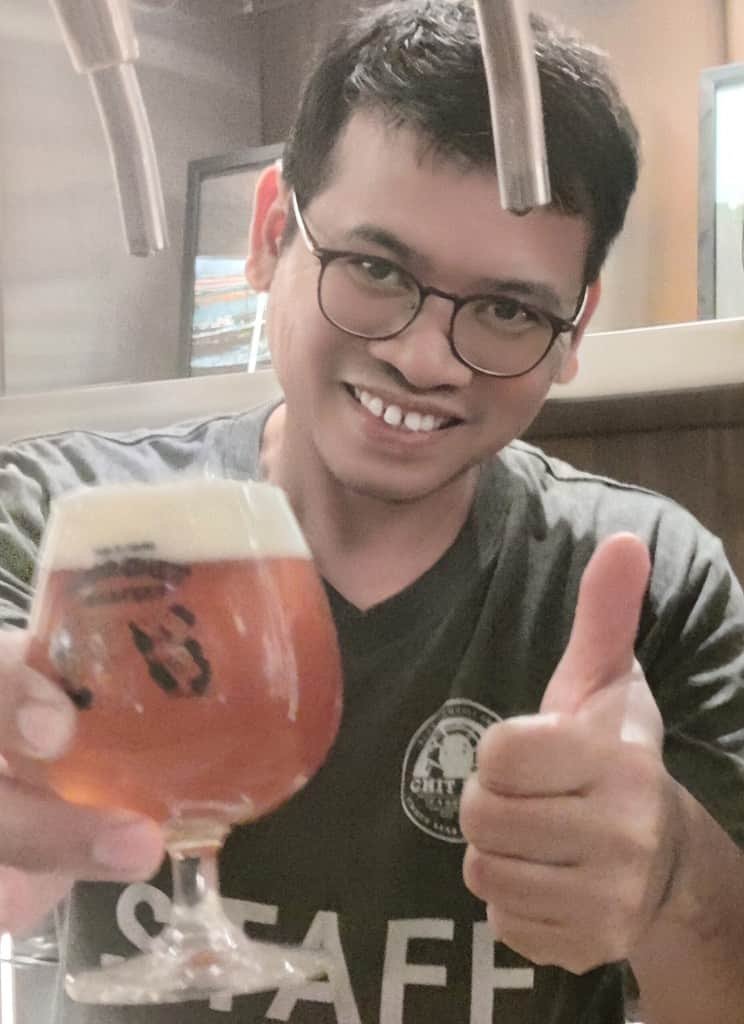 Thumbs up given by staff serving a glass of Chit Beer at Public House in Bangkok Thailand