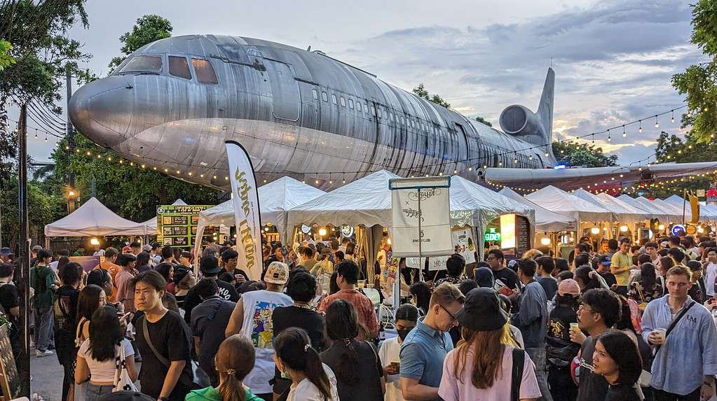 Beer Market 2 by ประชาชนเบียร์ (Beer People) at Chang Chui Creative Park in Bangkok. Large airplane above the brewery tents and beer drinking crowd in Thailand's capital.