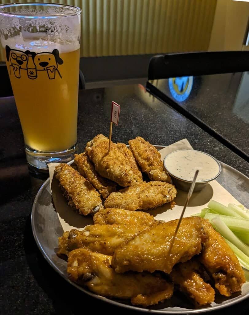 A pint of beer and some fried chicken wings at Hazy Hound, craft beer bar in Bangkok Thailand. 