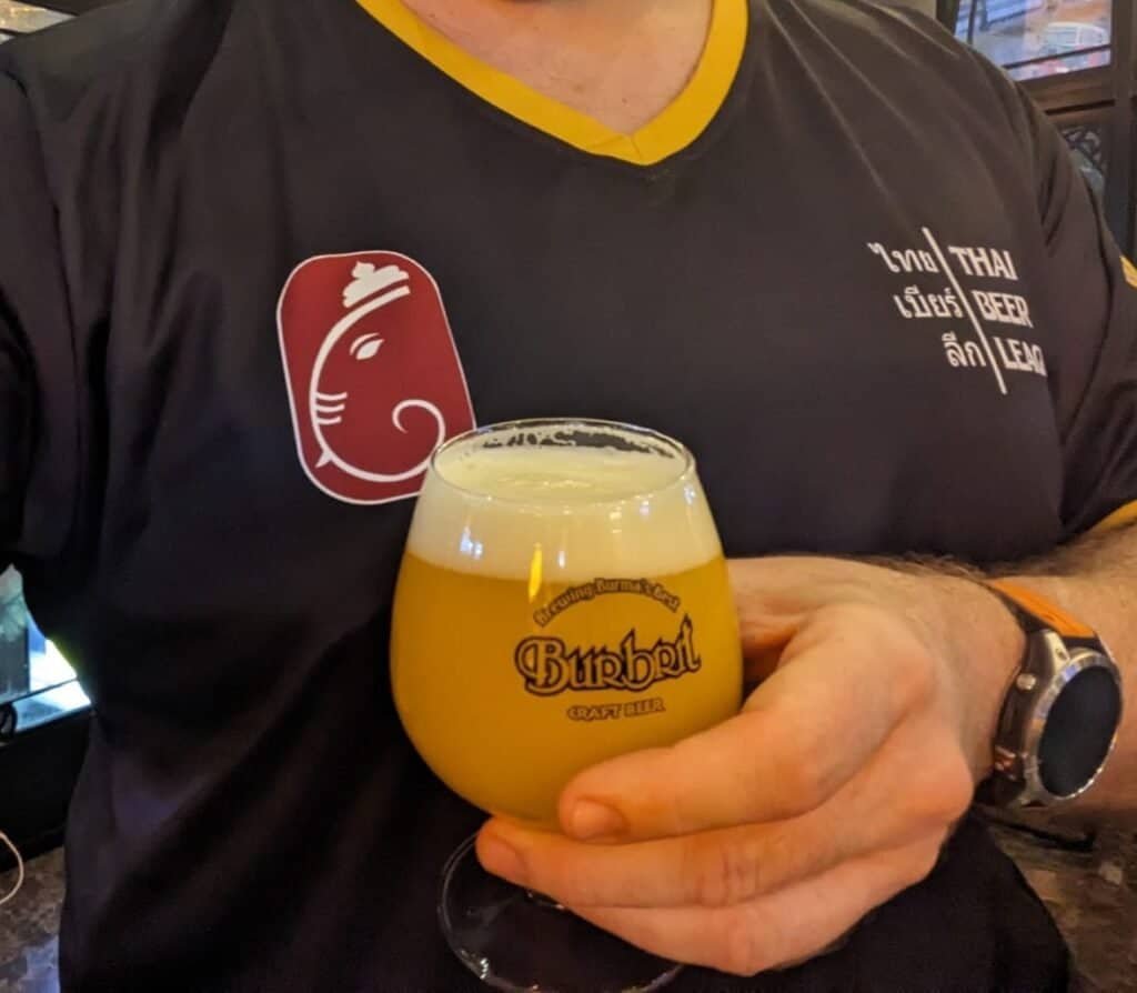 Thai Beer League shirt wearer showing off a hazy IPA at Burbrit Craft Beer bar in Sukhumvit in Bangkok THailand. 