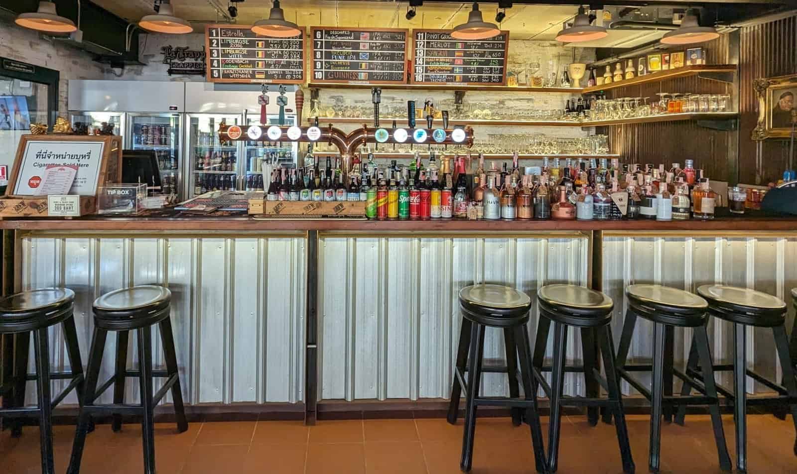 View of the bar at BREW beers and ciders in Bangkok, Thailand; many craft beers and bottles on display