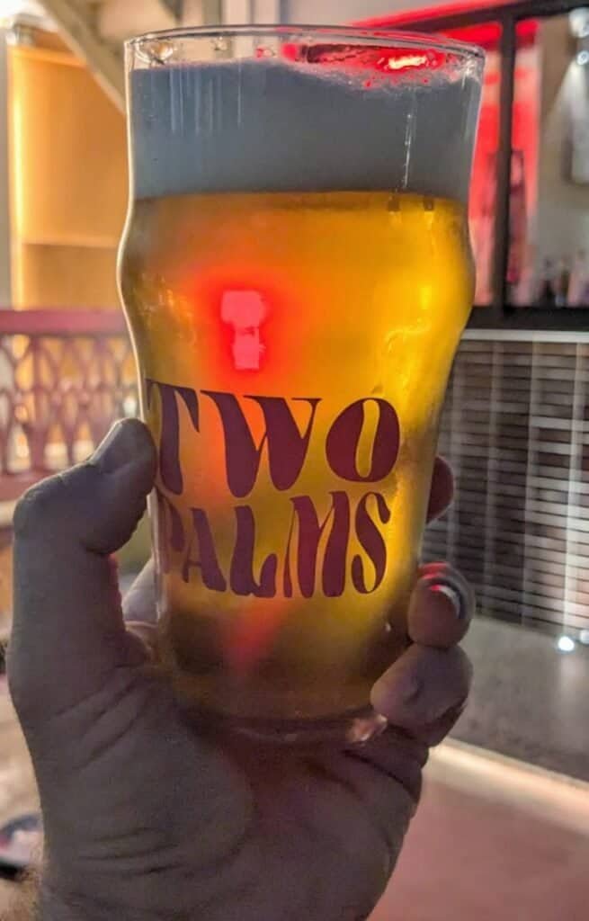 holding a branded beer glass at Two Palms soft open in Bangkok Thailand